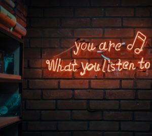 a small neon sign saying that you are what you listen to