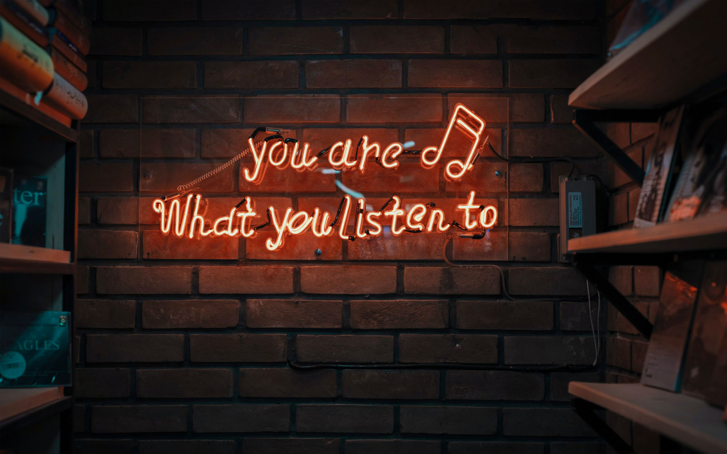 a small neon sign saying that you are what you listen to